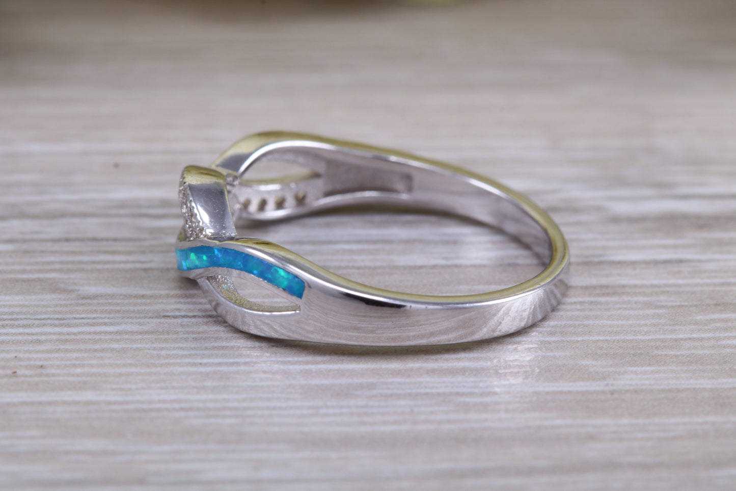 Fiery Blue Opal and cubic zirconia set cross over ring, solid sterling silver ring further rhodium plated for that platinum look