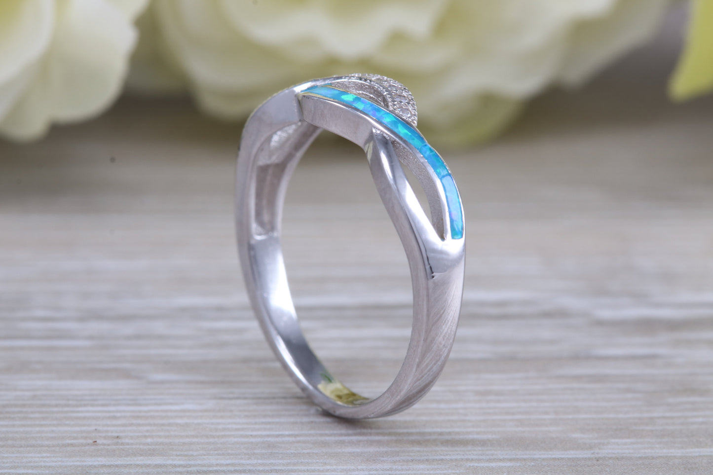 Fiery Blue Opal and cubic zirconia set cross over ring, solid sterling silver ring further rhodium plated for that platinum look